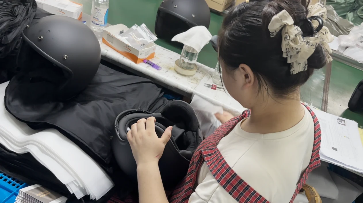 Worker doing the final assembly check at the workbench, testing every finished helmet